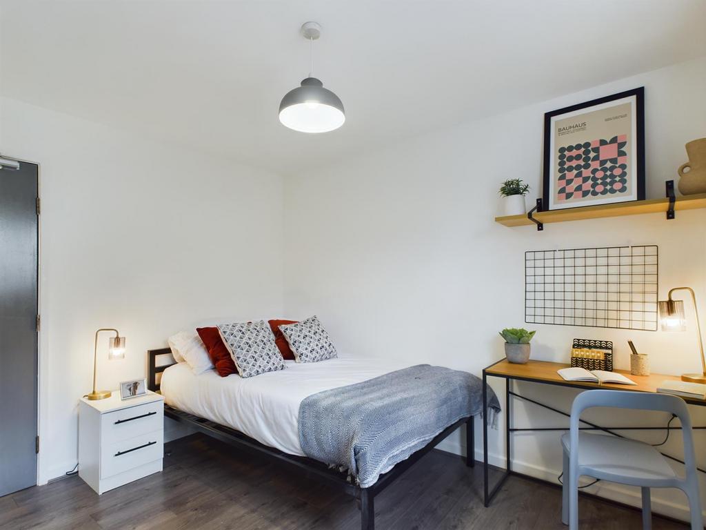 A modern and tidy bedroom featuring a comfortab...