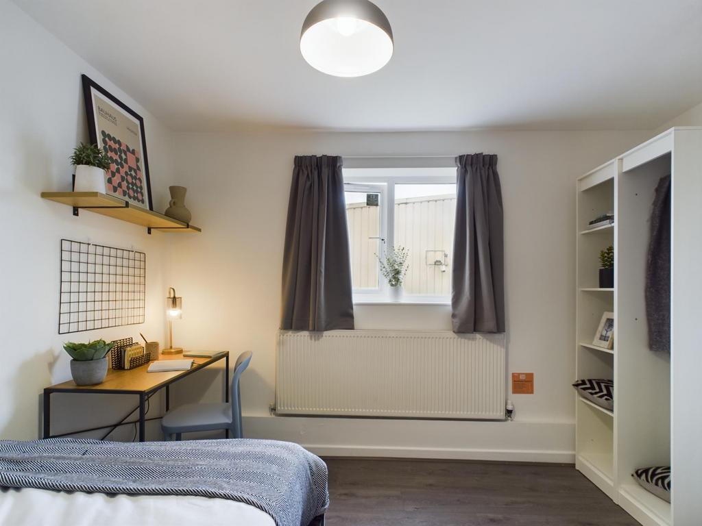A bright and tidy bedroom featuring a comfortab...