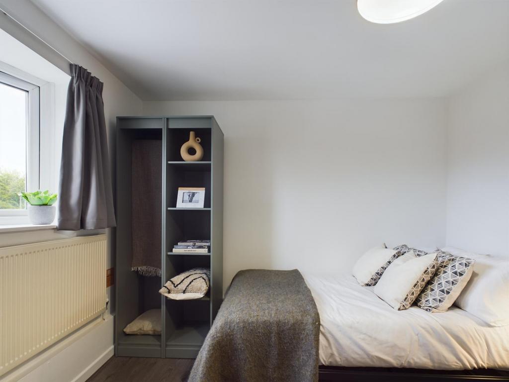 A cozy and well-maintained bedroom featuring a ...