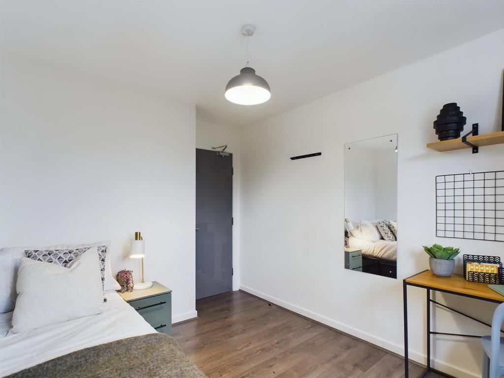 A bright and tidy bedroom featuring a comfortab...