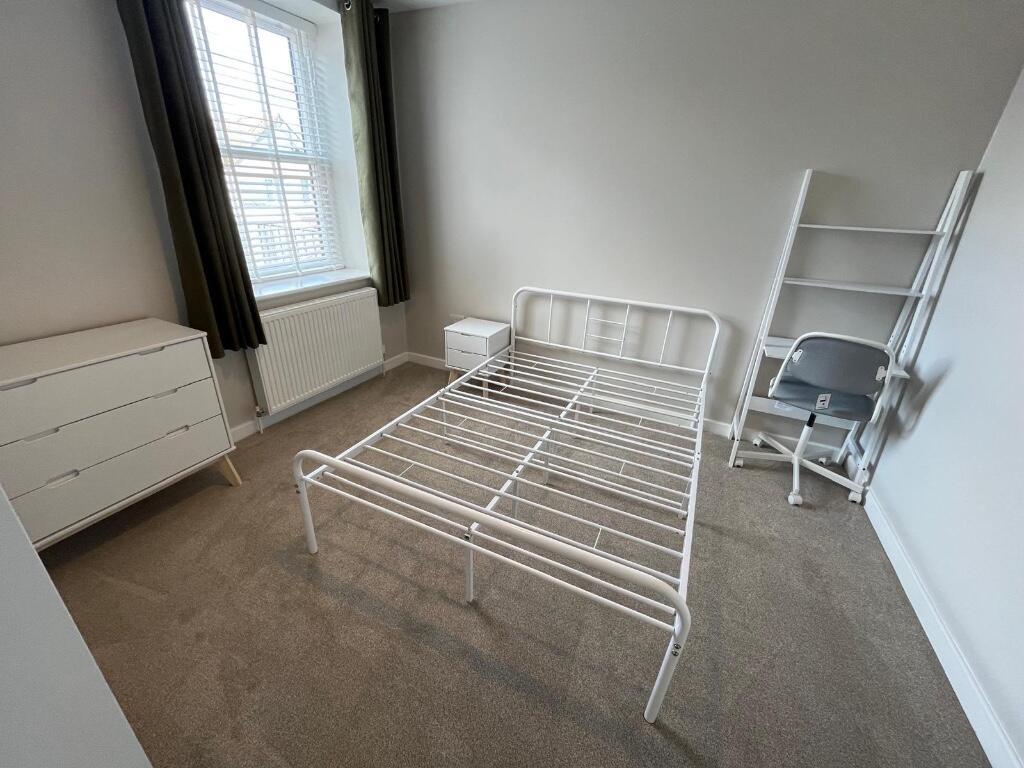 A bright and minimalistic bedroom featuring a m...