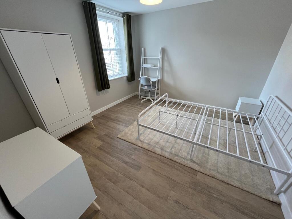 A bright and airy master bedroom featuring a la...