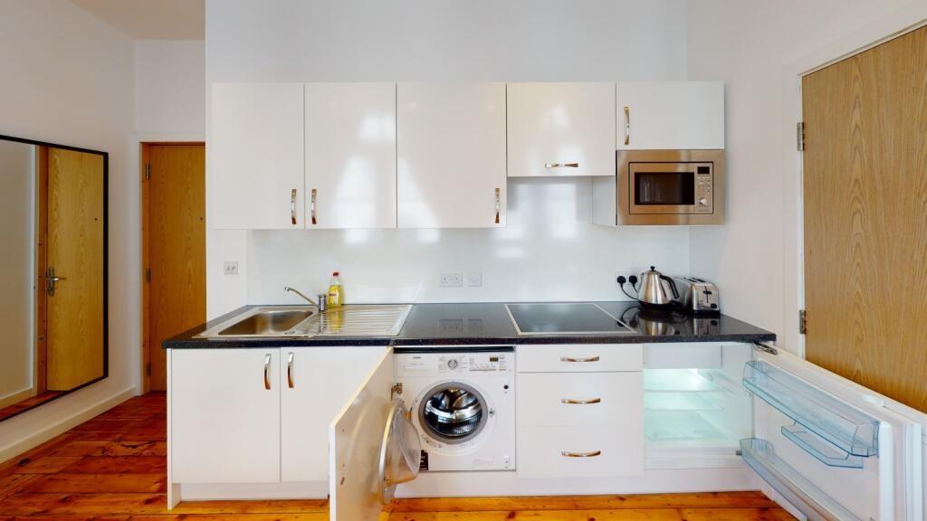 Bright and modern kitchen with clean white cabi...