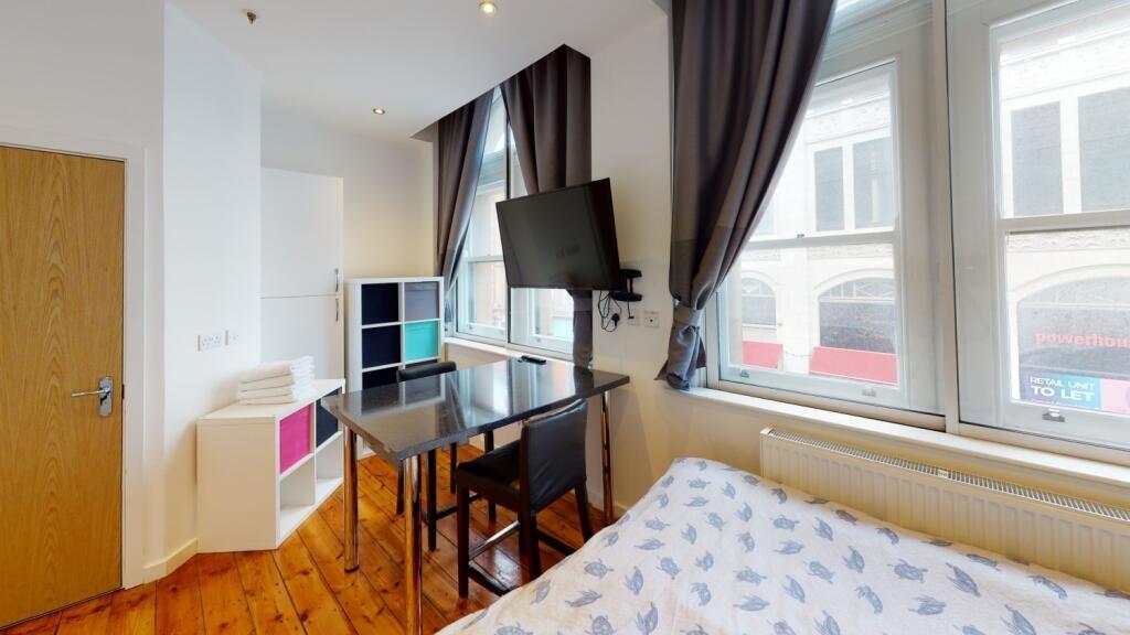 Bright and tidy bedroom featuring large windows...