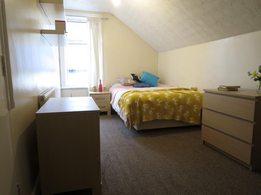 A cozy double bedroom with a comfortable bed dr...