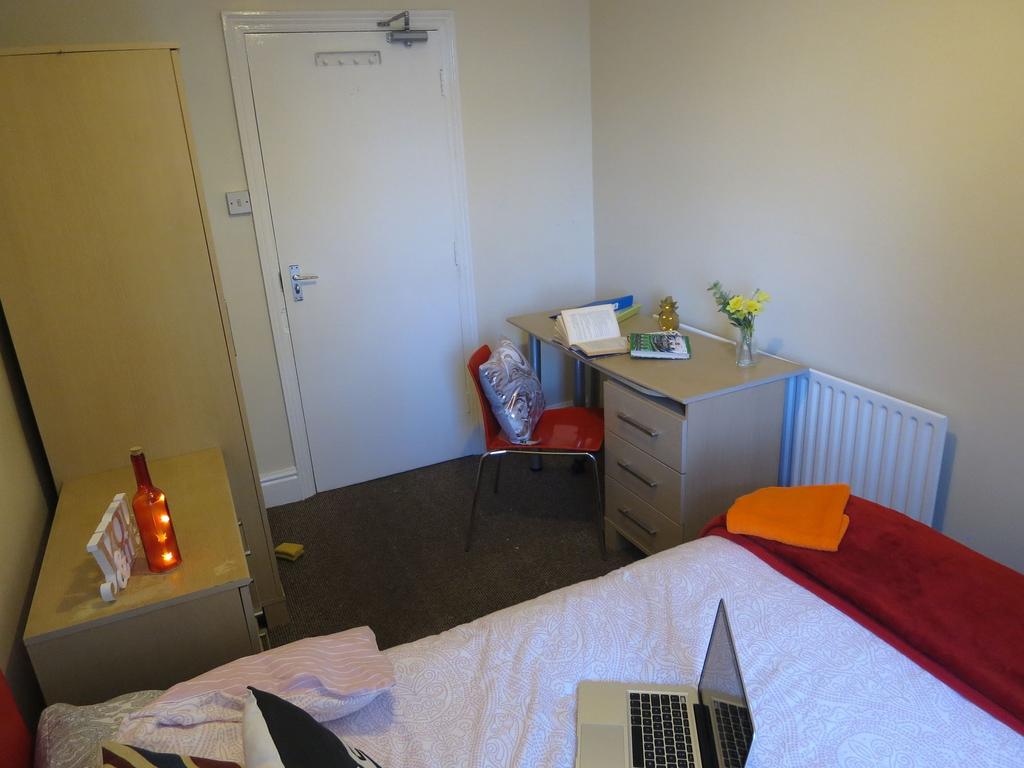 A well-kept bedroom featuring a single bed with...