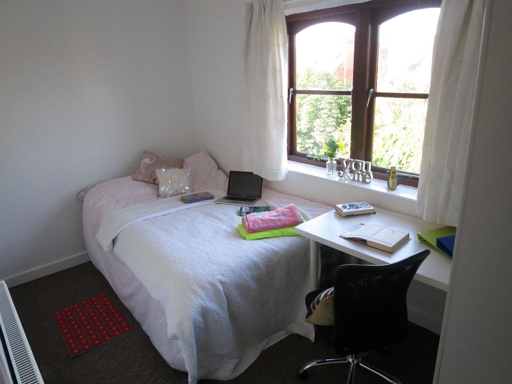 A cozy bedroom featuring a neatly made bed with...