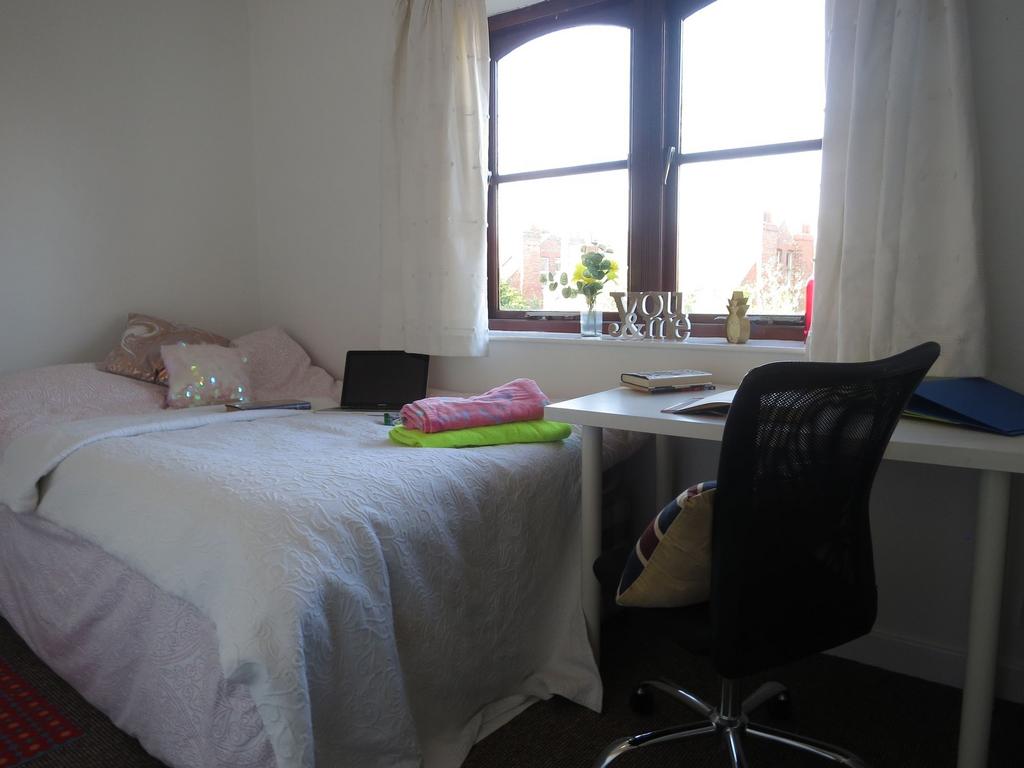 A cozy bedroom featuring a neatly made bed with...