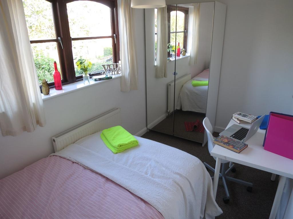 Bright and tidy student bedroom featuring a com...