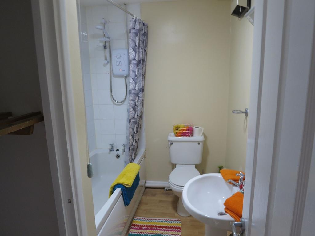 A tidy and functional bathroom featuring a bath...