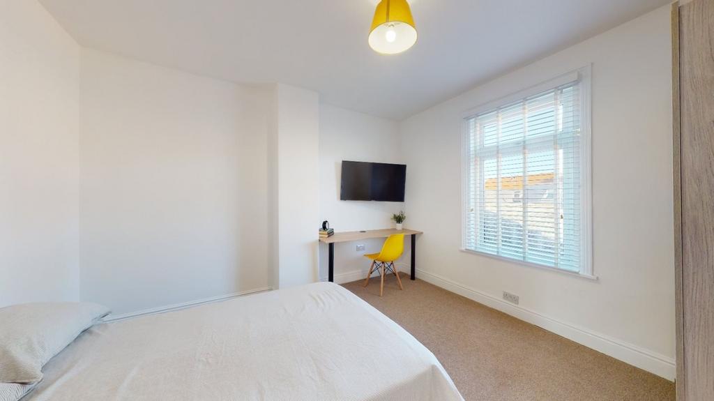 A bright and welcoming bedroom featuring a larg...