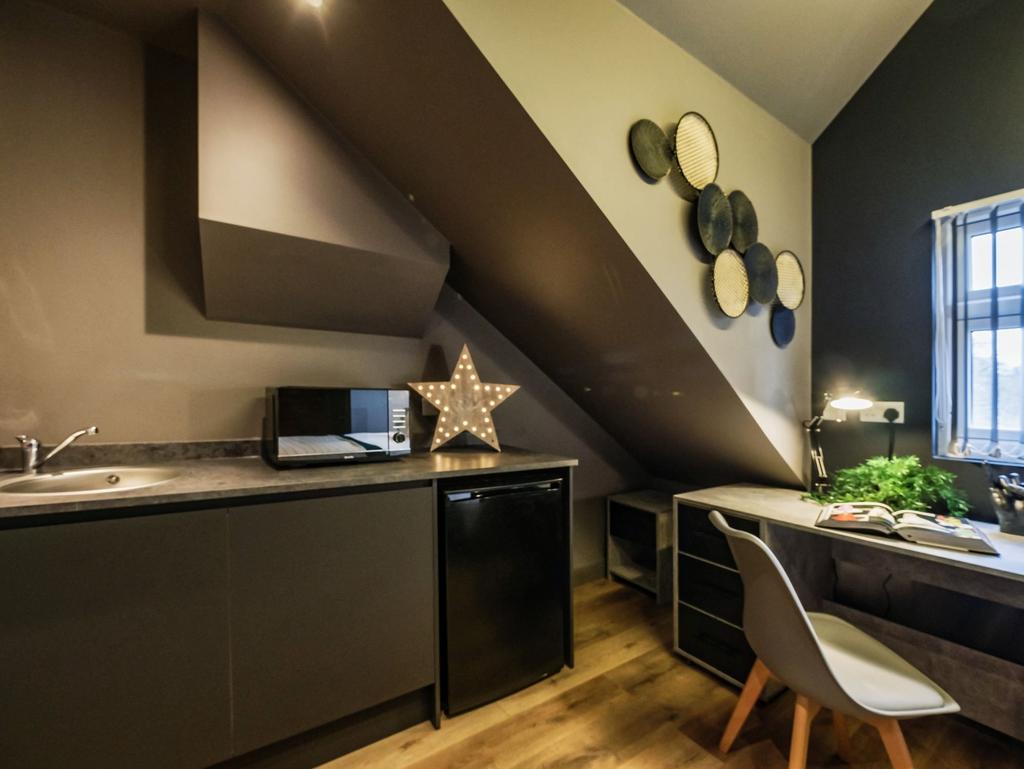 Stylish kitchenette with modern dark cabinetry,...