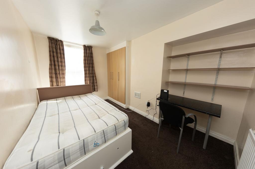A cozy single bedroom featuring a comfortable b...