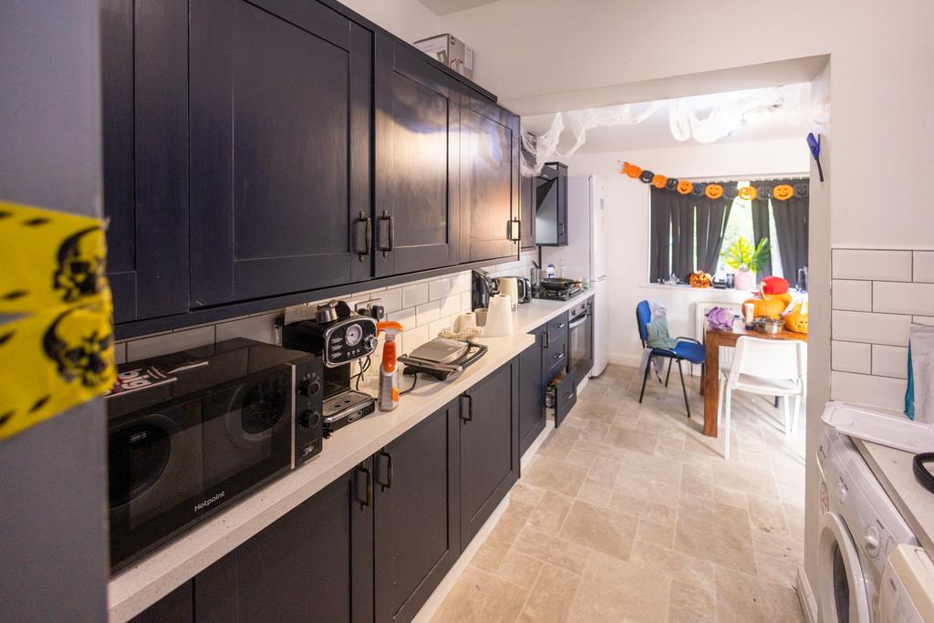 A modern kitchen with dark cabinetry and a whit...