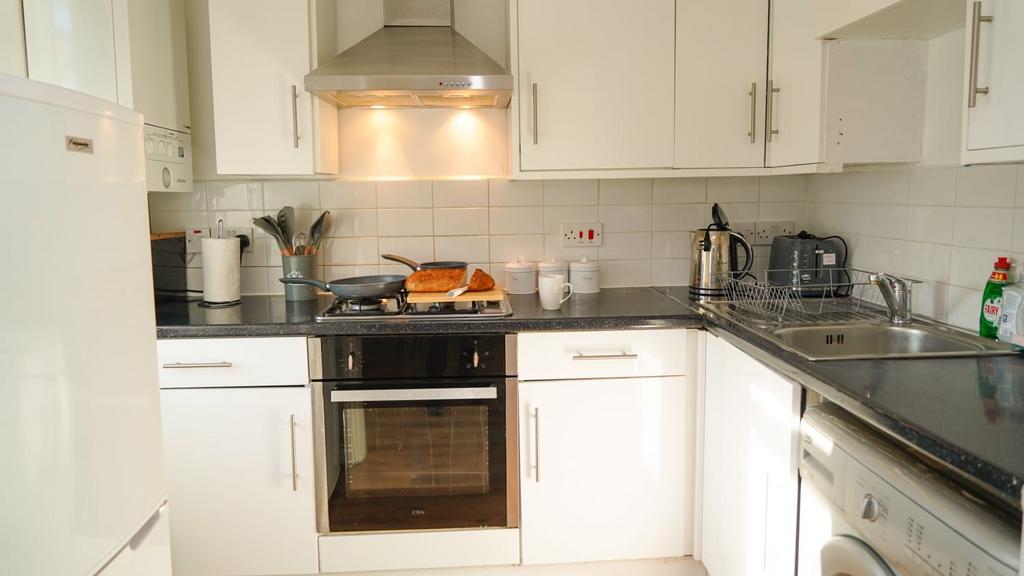 Bright and modern kitchen featuring white cabin...