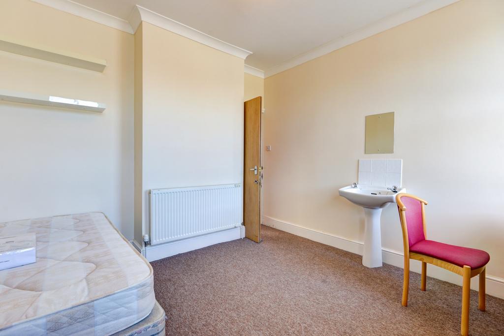 A simple and tidy single bedroom featuring a be...