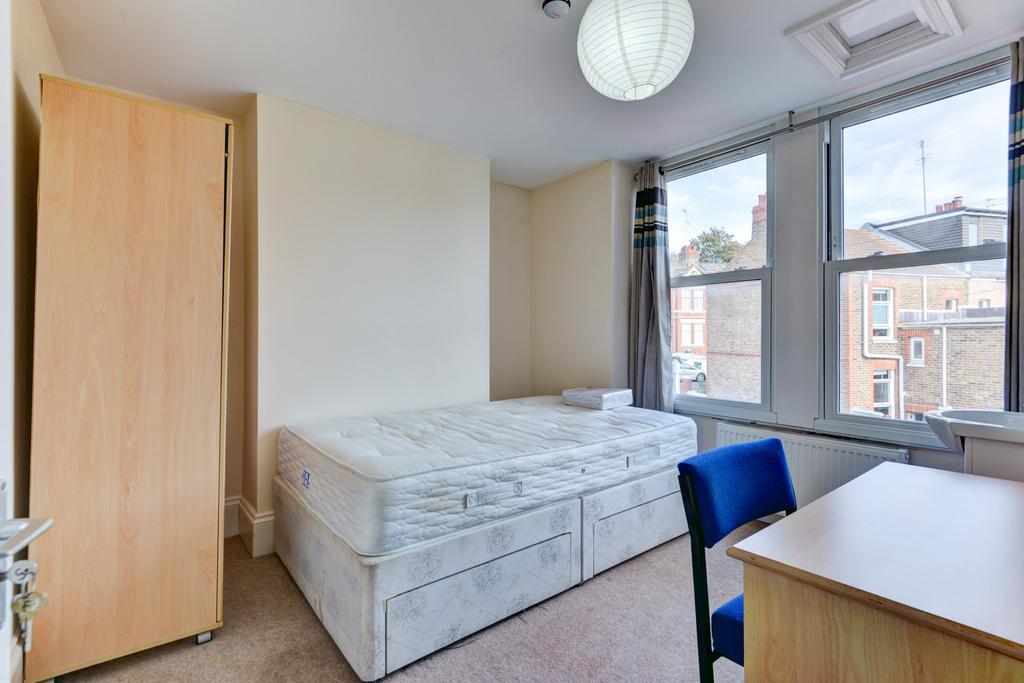 A bright double bedroom featuring a comfortable...