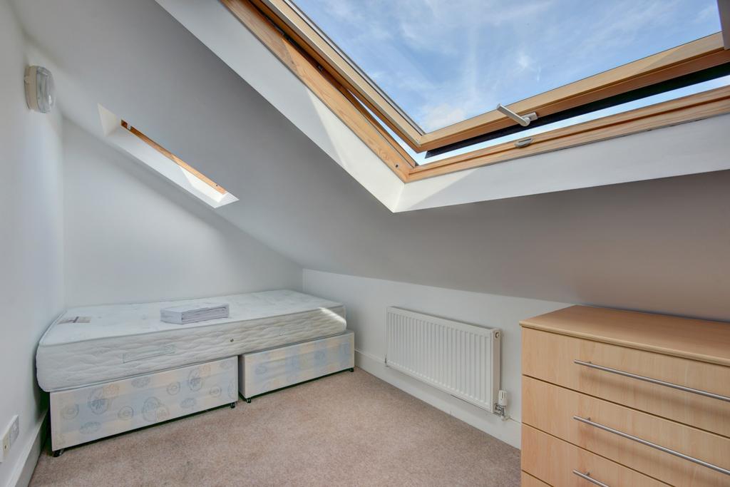 Bright and cozy attic bedroom featuring a comfo...