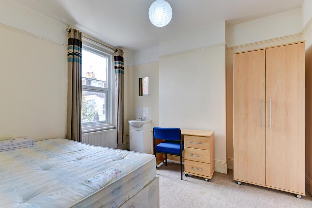 A bright, clean single bedroom featuring a comf...