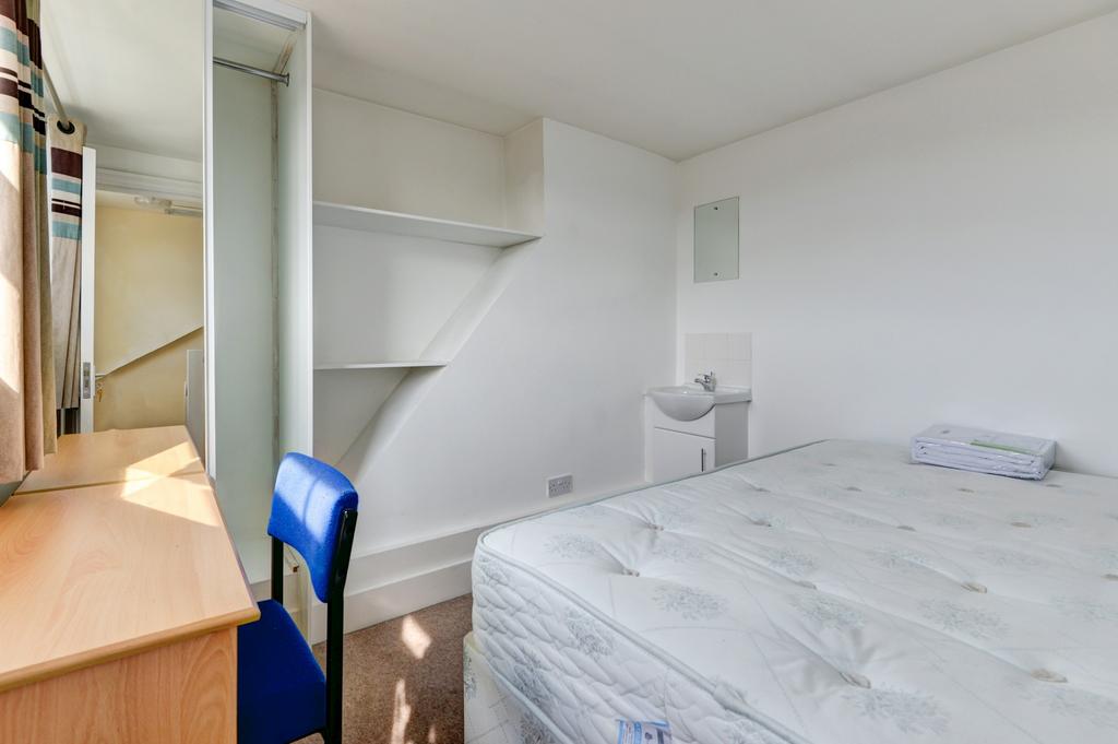 A bright and tidy single bedroom featuring a co...