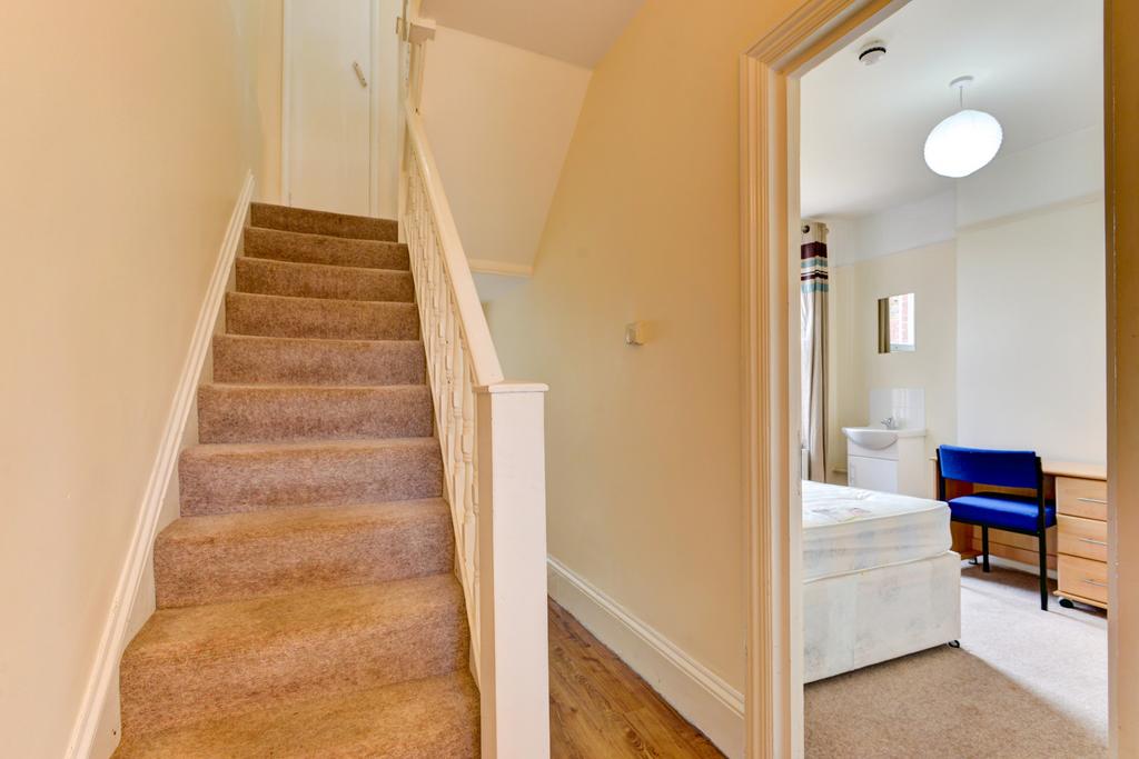 A well-maintained carpeted staircase with neutr...