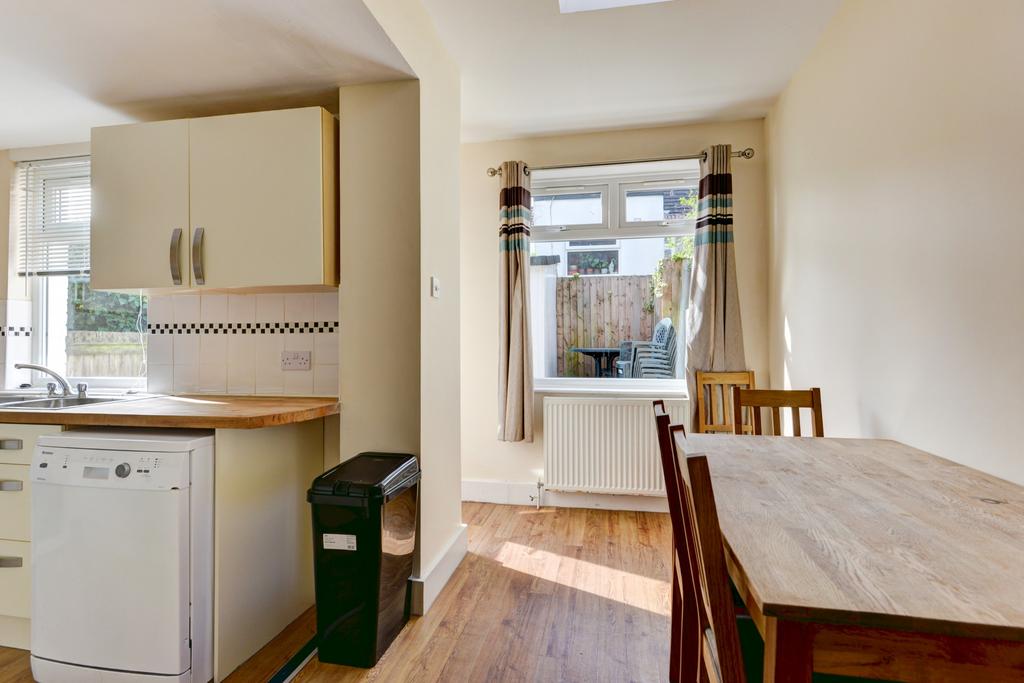 Bright and tidy kitchen-dining area featuring n...