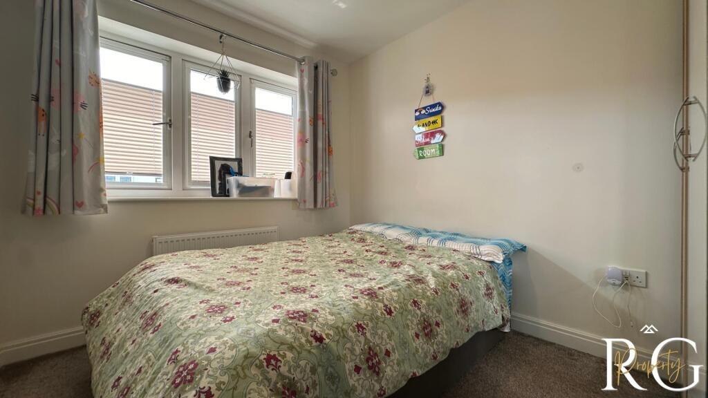 A cozy bedroom with a comfortable bed, a window...