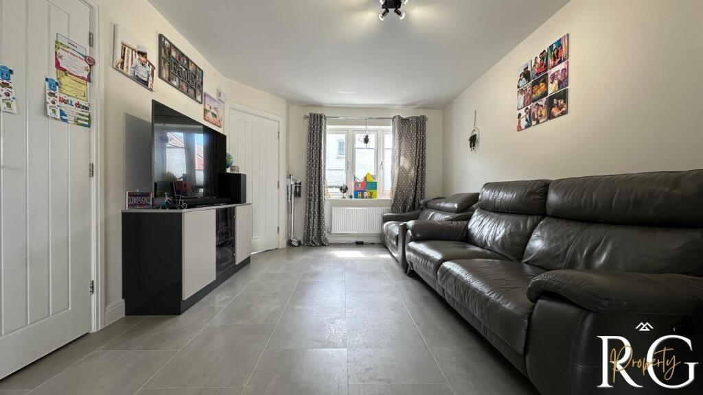 A spacious and well-lit living room featuring a...