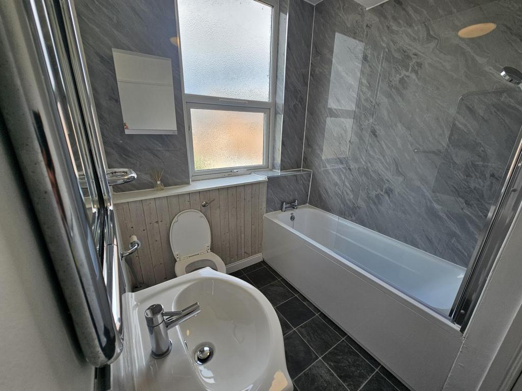 A well-maintained bathroom with a clean bathtub...