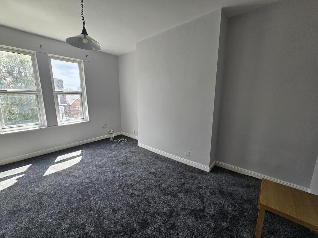Bright, neutral bedroom with large windows lett...