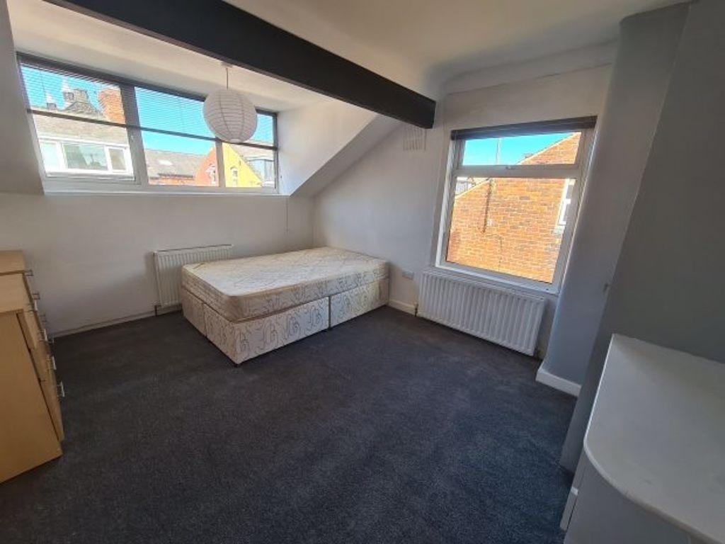A bright single bedroom featuring two large win...