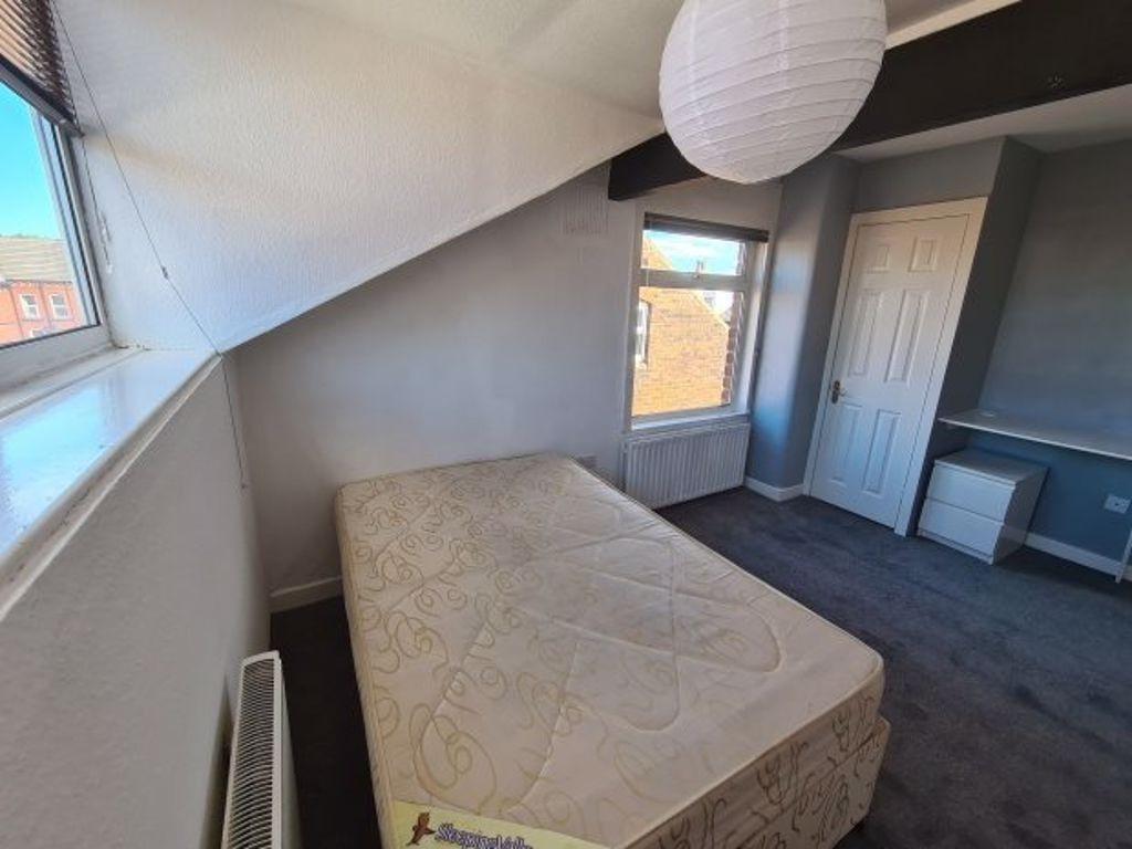 Bright single bedroom featuring a large window ...