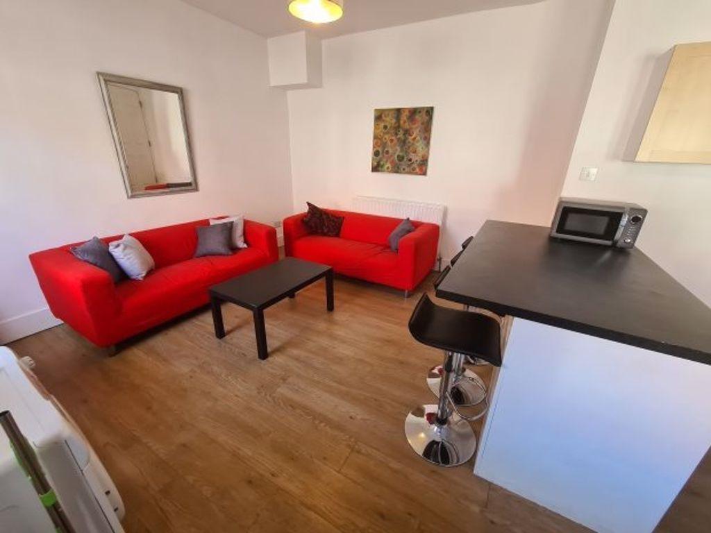A cozy living room featuring bright red sofas, ...