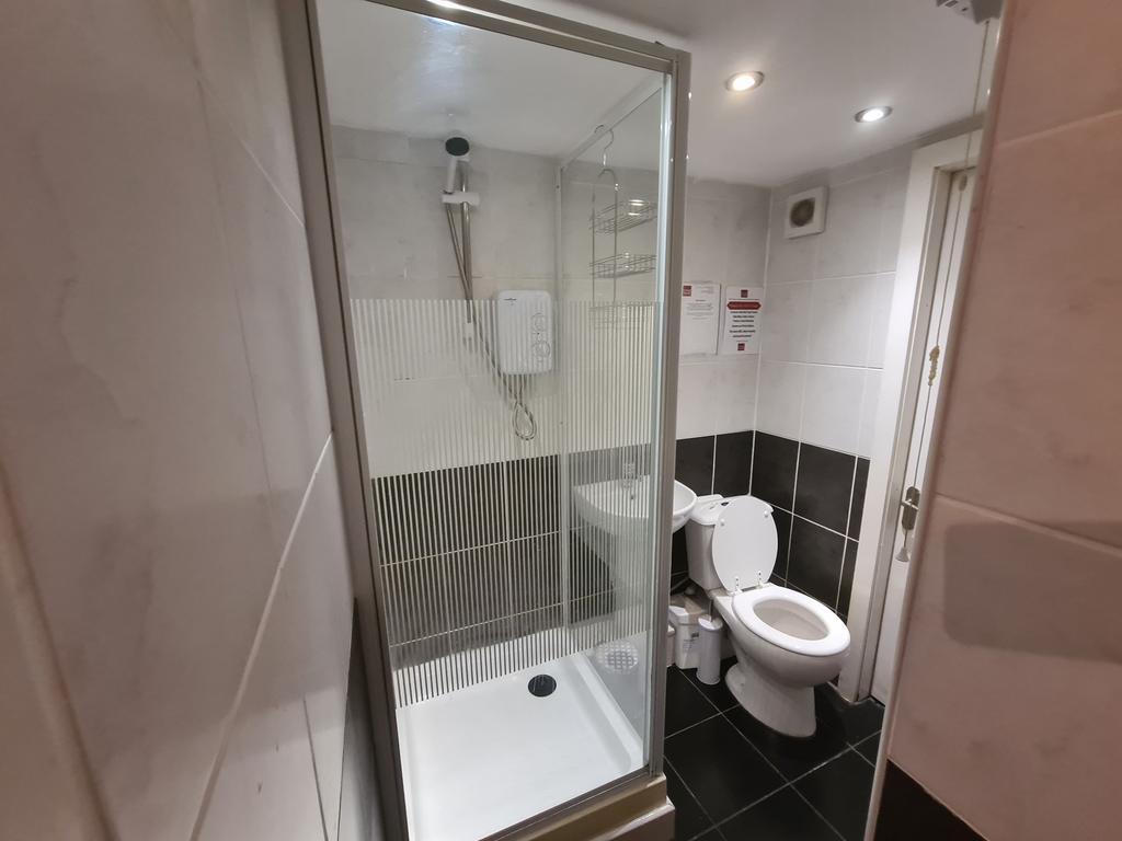 A modern bathroom featuring a spacious glass-en...