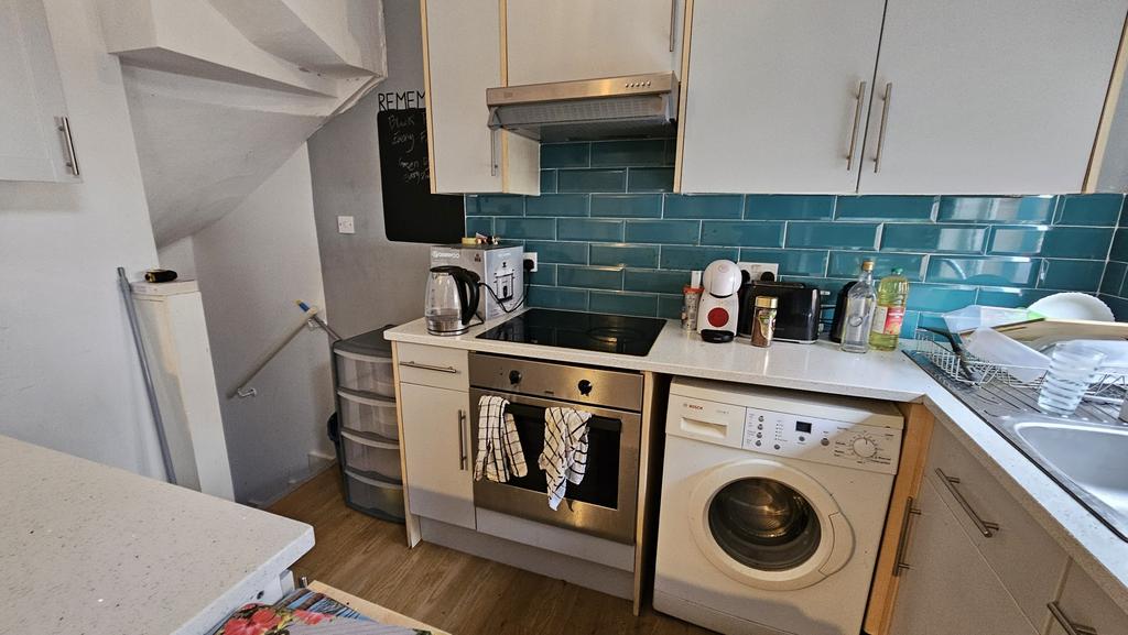Compact and modern kitchen space featuring whit...