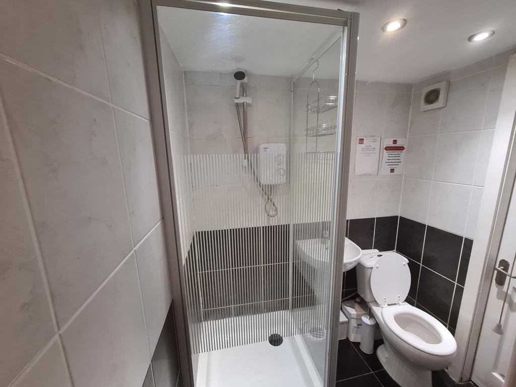 A modern bathroom suite featuring a glass-enclo...