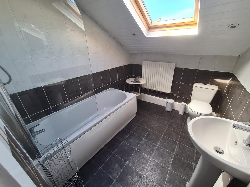 Bright and modern bathroom suite featuring a ba...