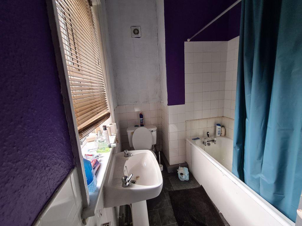 A neat and functional bathroom featuring a whit...