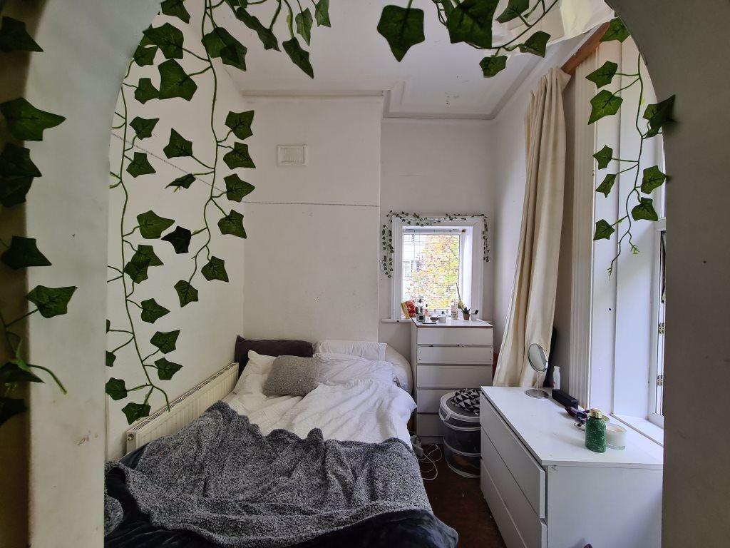 A cozy single bedroom featuring a neatly made b...