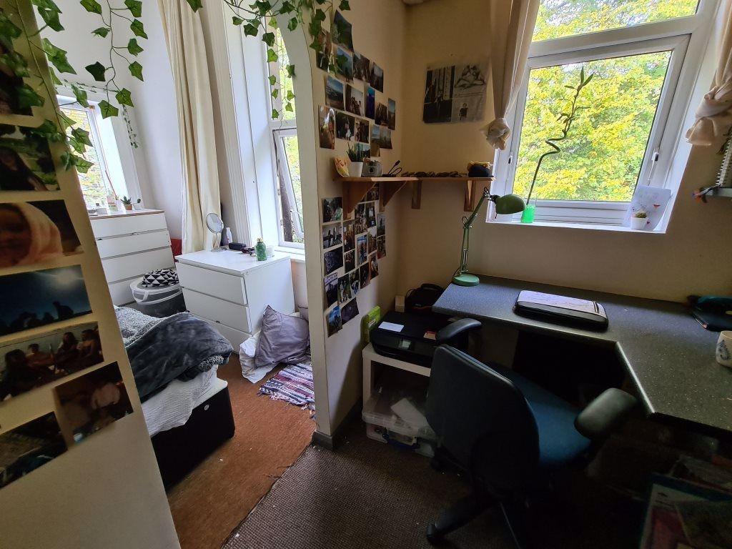 Cozy single bedroom with a study desk positione...