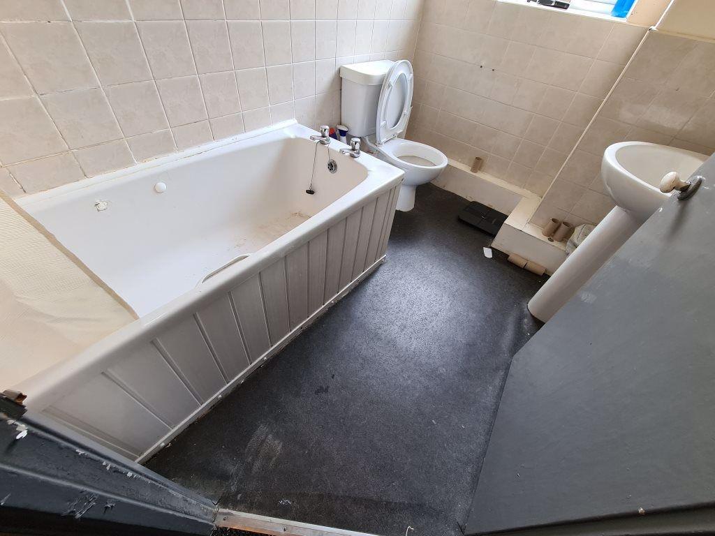 A bright and clean bathroom suite featuring a s...