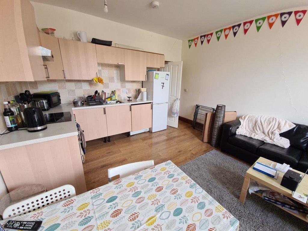 A bright and tidy living room featuring a comfo...