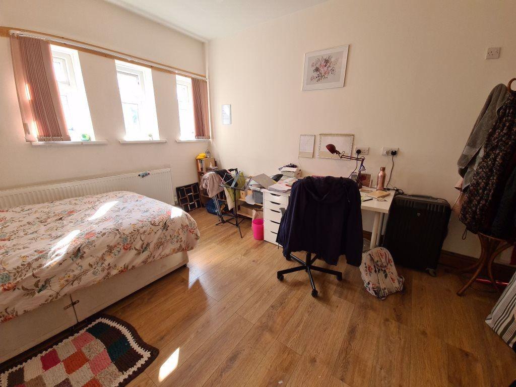 A cozy single bedroom with a large window allow...