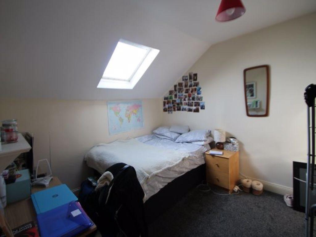 A cozy attic bedroom featuring a skylight that ...