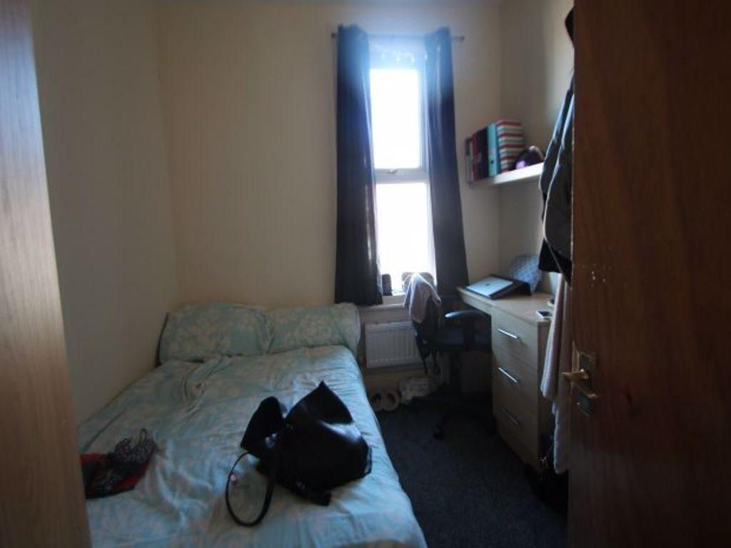 Cozy single bedroom featuring a comfortable bed...
