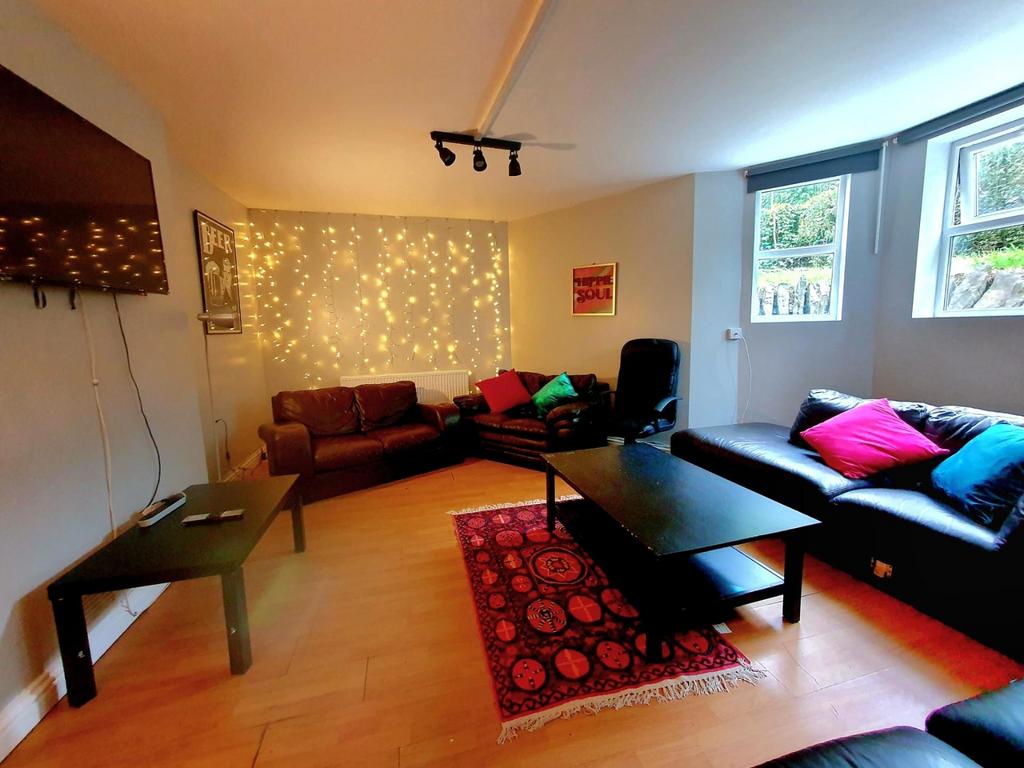 A cozy, well-lit living room featuring comforta...