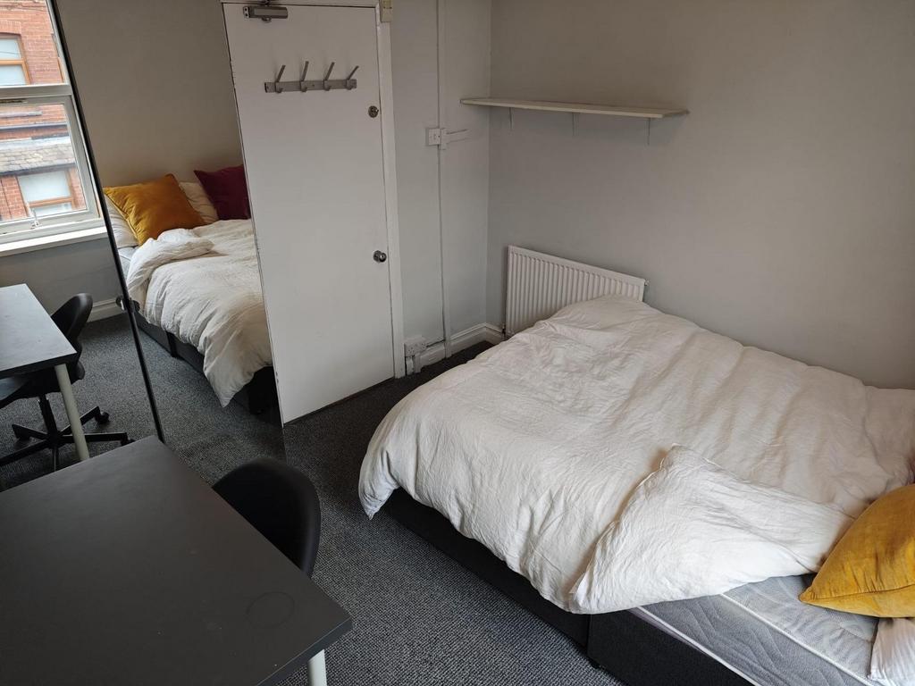 A bright and tidy single bedroom featuring a co...
