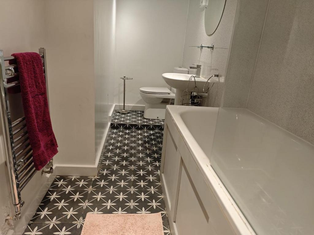 A stylish bathroom featuring a modern bathtub, ...