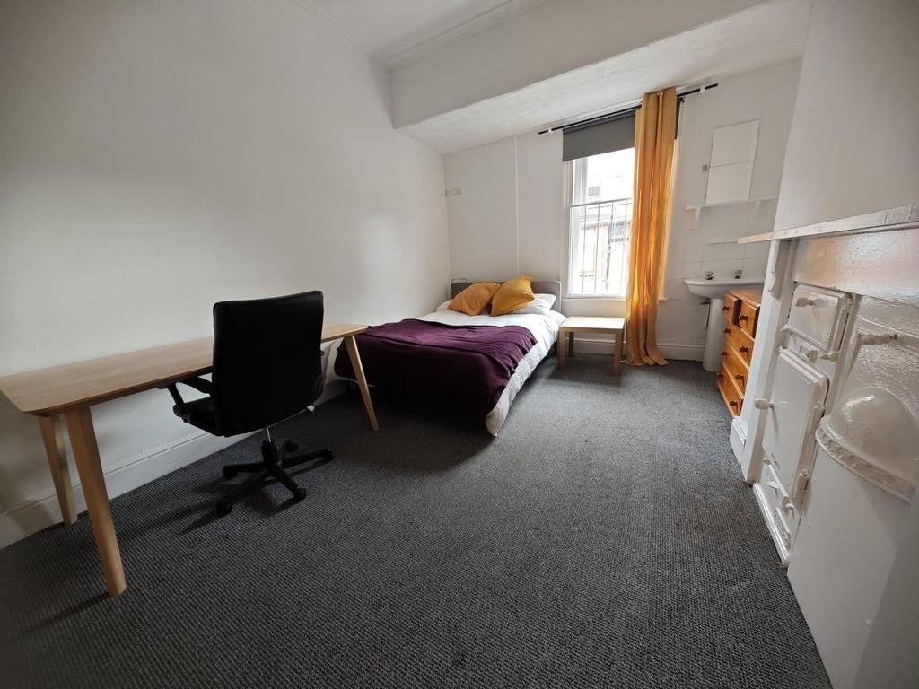 A bright and tidy master bedroom featuring a co...