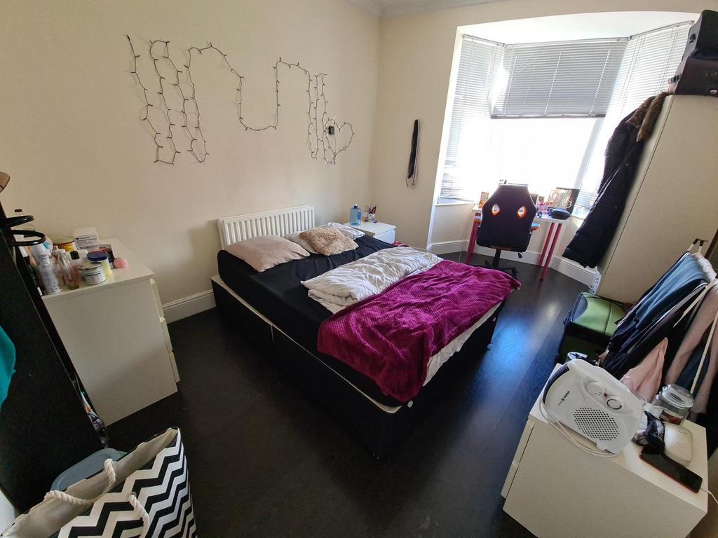 A cozy bedroom featuring a double bed with pink...